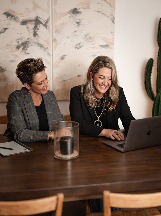 Cara Christenson and JoDee Turner working together on website support